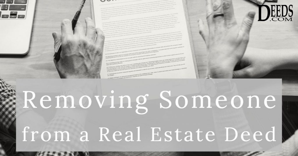 Image of two people at a desk with real estate deed discussing removing one of them from the deed.