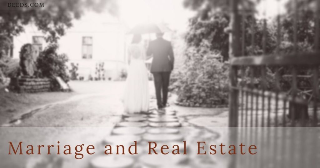 Image of a couple under an umbrella walking down a path towards a house appearing to be in a wedding, getting married. Captioned: Marriage and Real Estate