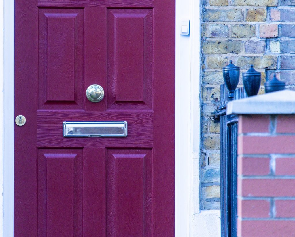 Close up image of a dark red door on a house. Captioned: Bargain and Sale Deed vs. Quitclaim Deed