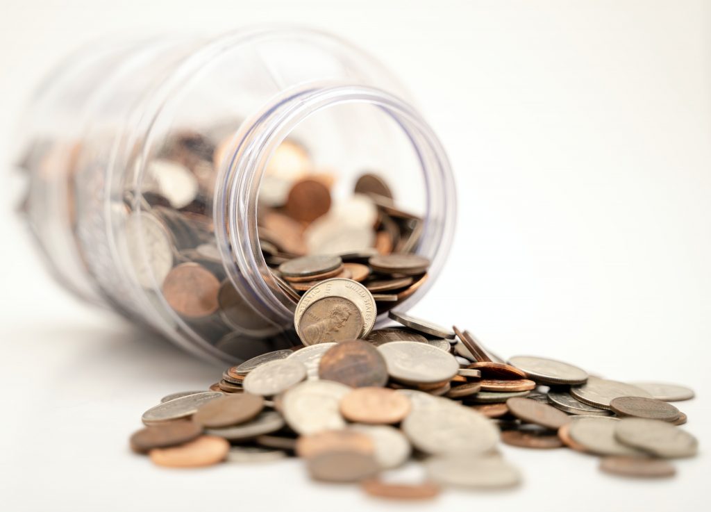 Image of a tipped over glass jar of coins captioned: How Home Equity Lines of Credit Impact a Home's Title