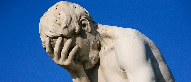 Image of an old statue depicting a person with their face in their hand apparently frustrated. Captioned: Indiana's Botched Notary Law Update.