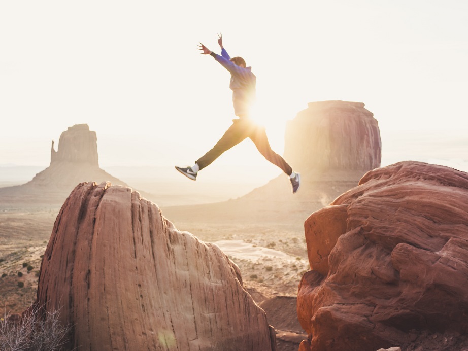 Image of a person leaping across large boulders with the sun shining brightly at their back. Captioned: Ready For Sole Homeownership?