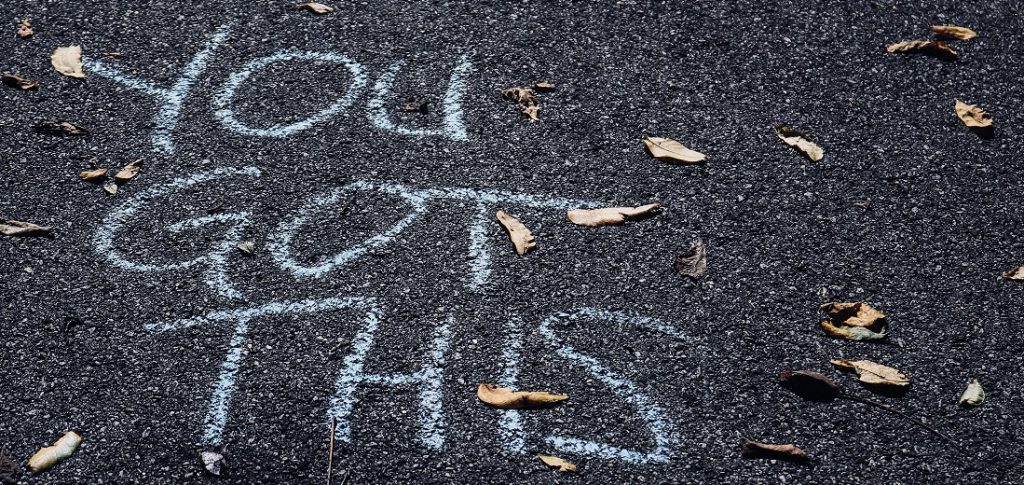 Image of chalk writing on pavement saying: You Got This. Captioned: The unbearable Stress of Buying a Home, and Survival Tips