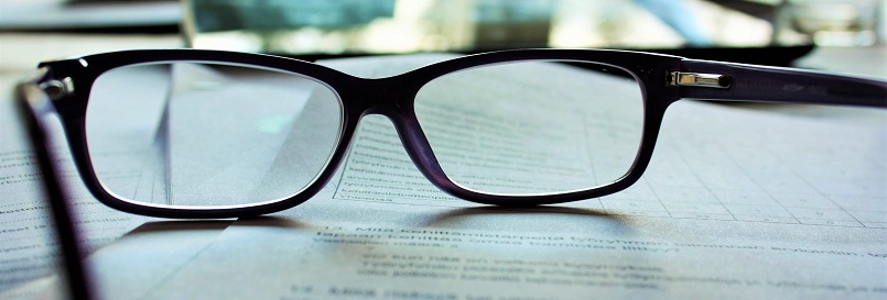 Image of reading glasses laying on paperwork. Captioned: An Opinion of Title: What Home Buyers Should Know