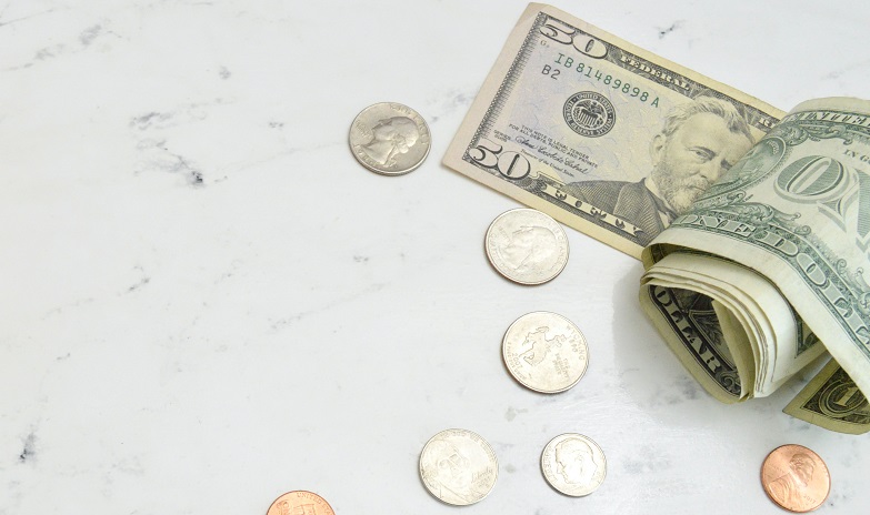 Image of money scattered on a table top. Captioned: Get the Facts on Credit Scores