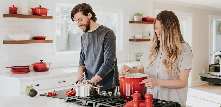 Image of a seemingly happy couple in a kitchen, cooking together. Clearly a fantasy piece that will make any couple married for longer than 48 hours throw up in their mouth a little bit... enjoy.