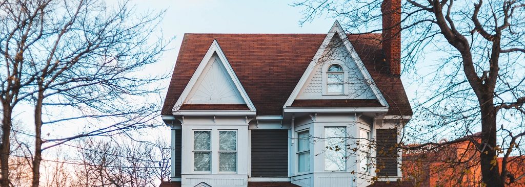 Image of the front of an older two story house. Captioned: Guide to Buying an Estate Sale Home