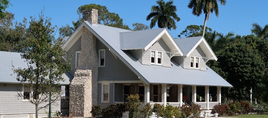 Image of a nice newer house with a fantastic stone chimney . Captioned: Choosing Between Standard and Extended Title Insurance