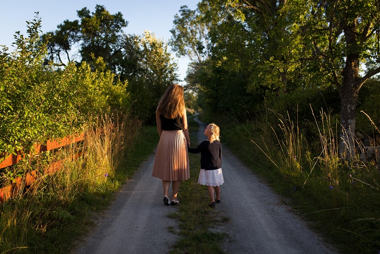 Image of two people, one younger and one older, walking along a path. Captioned: The Life Estate Deed. Does it Fit Into Your Estate Planning?