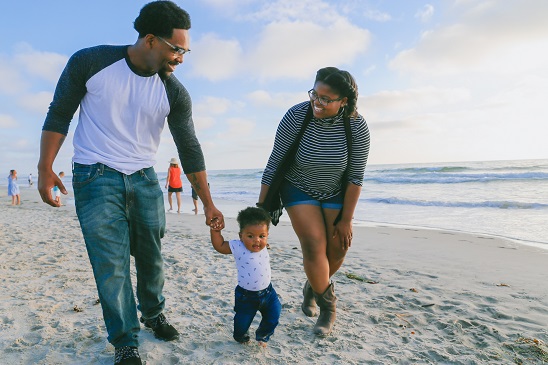 Image of a happy family walking on the beach.