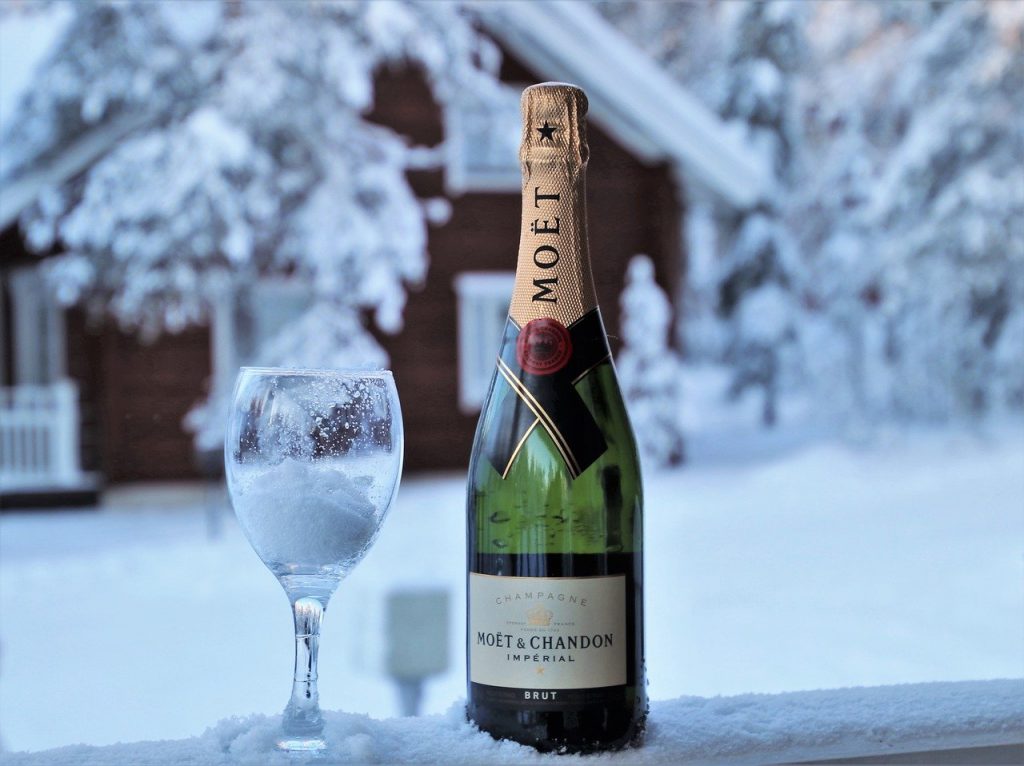 Image of a glass and a bottle of champagne sitting outside preparing for a celebration.