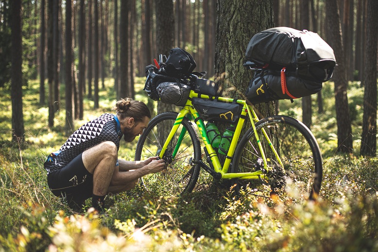 A person in the woods fixing a bicycle. Captioned: Strengthen Your Position to Finance Your Home