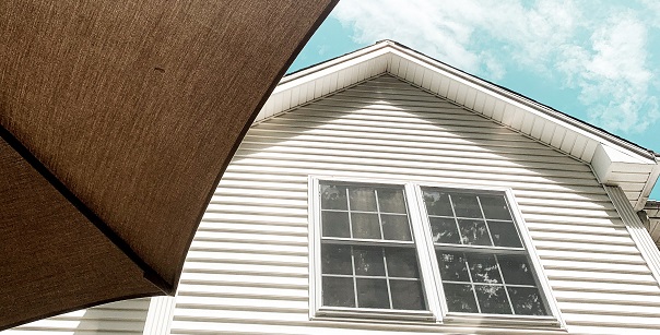 Image of a side of a house from the ground looking up. Captioned: Should a House Be in an Irrevocable Trust?