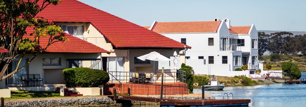 Image of a row of vacation homes near the water. Captioned: QPRT: Pertinent to Your Estate Planning Goals? Information regarding a qualified personal residence trust.