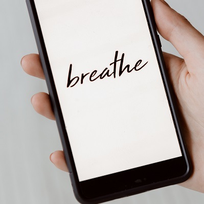 Image of a person's hand holding a smart phone with the word breath written on the screen. Captioned: What’s the Latest on Covid Mortgage Relief?
