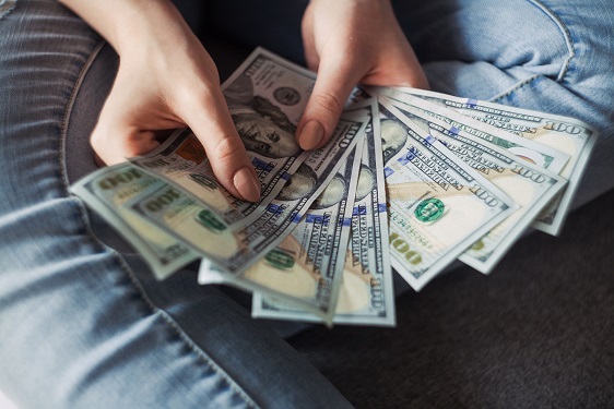 A person sitting cross-legged while fanning out cash in their hands. Captioned: When Your Mortgage Repayment Options Are Unmanageable
