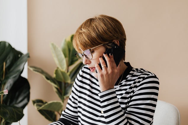 A person on the phone falling for a real estate closing scam.