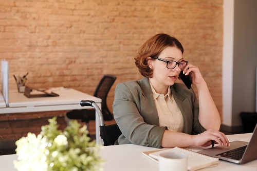 Image of a person on the phone, sitting at a desk in a casual office setting. Captioned: Be Aware of Unscrupulous Financing Practices