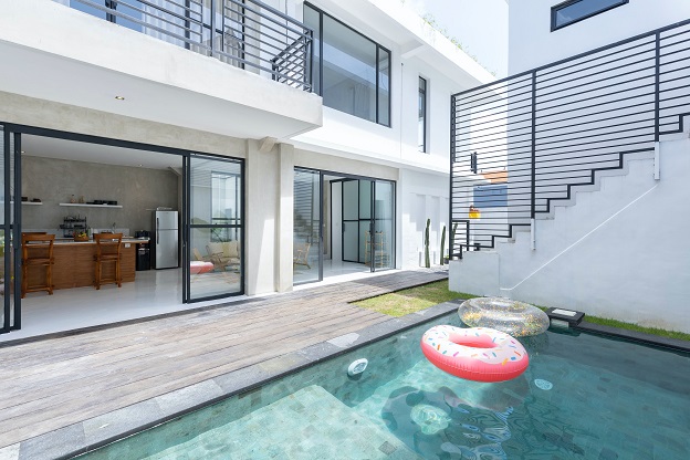 Image of a pool area surrounded by living area of a condo or house.