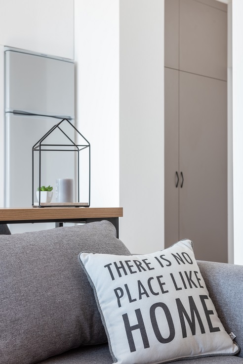 Image of the inside of a small house with a couch and a table.