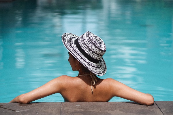 A person relaxing in a pool. Captioned: Do I Understand the HOA Tradeoff?