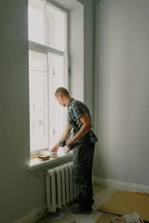 Image of a person working on house windows in an old house.