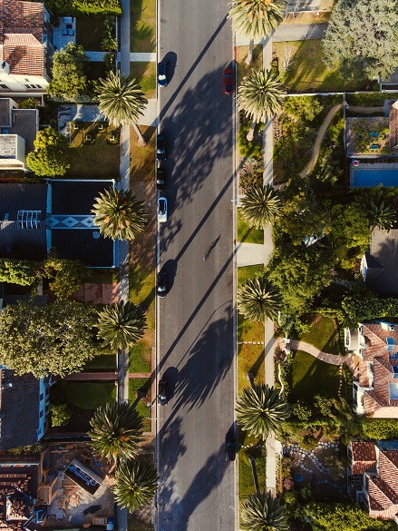 Aerial view of a palm tree lined street in California. Captioned: Heirs Will Still Get a Stepped-Up Tax Basis for Federal Capital Gains Tax Purposes
