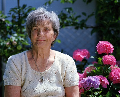 Image of a person sitting outside in front of a garden in Maine.