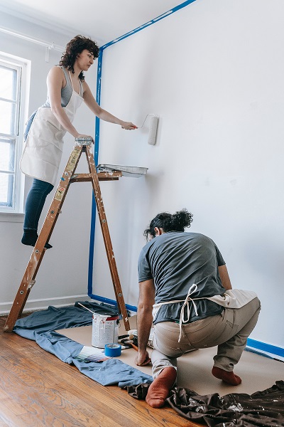 Image of two people painting the inside of a house