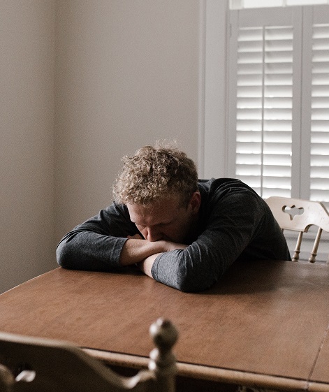 A person at a table while deep in thought.