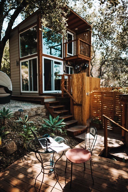 Image of a very nice tiny home with a patio and landscaping.