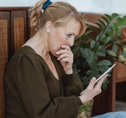 Person looking at a phone with a concerned look on their face.