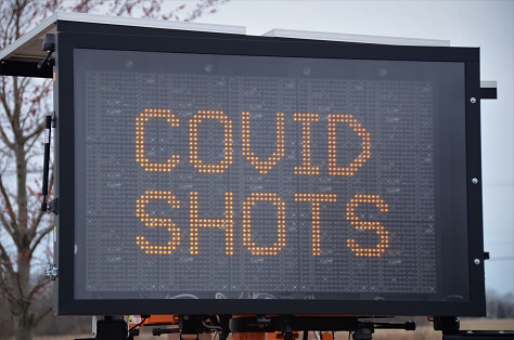 Image of a digital sign the reads: COVID SHOTS