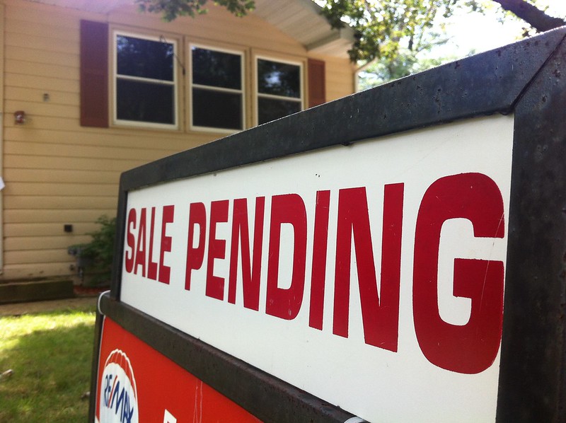 Image of a "sale Pending" sign in front of a house.