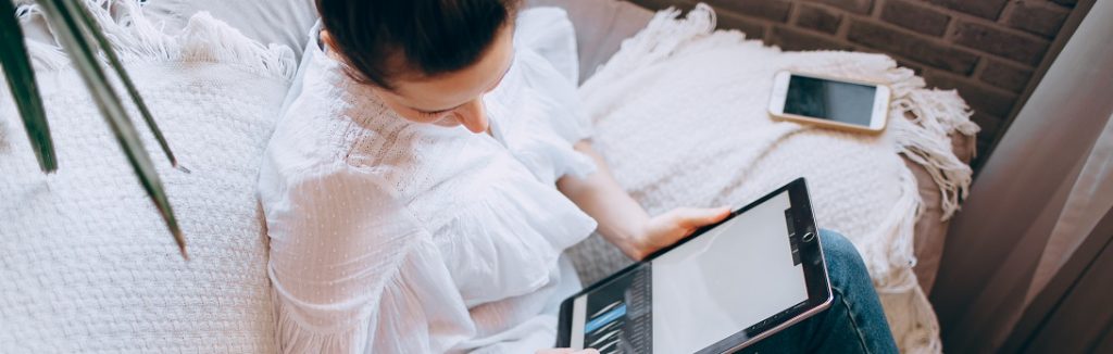 Person looking at a tablet computer. Captioned: Remote Online Notarization Wins Home Buyer Confidence