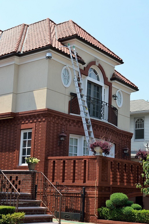 Image of the outside of a house with a ladder leaning against it.