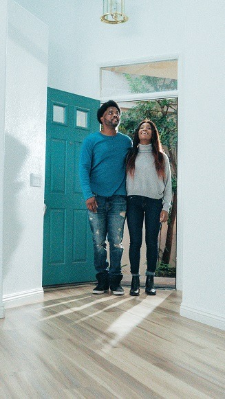 Two people walking into a house seemingly for the first time.
