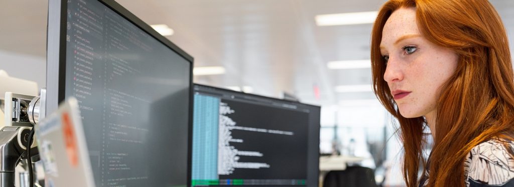 A person using several computers in an office setting.