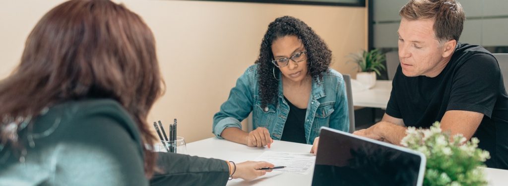 People sitting at a table reviewing a legal document.