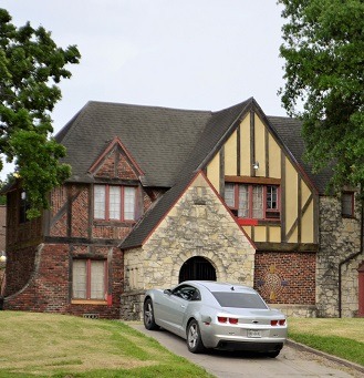 Image of an older, well kept, house with a newer car in the driveway