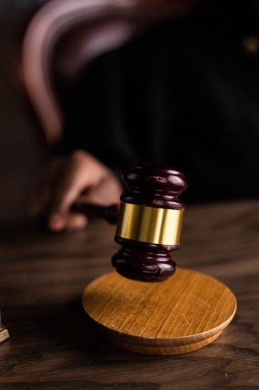 Blurry image of a judges gavel being held over a desk.