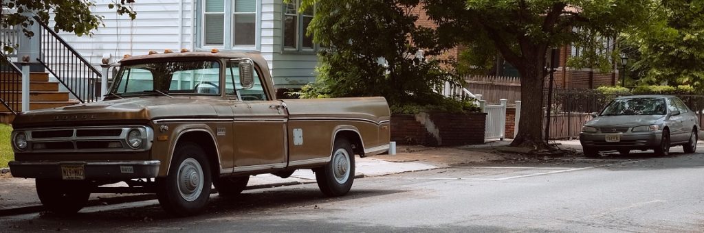 Image of cars sitting on a street in front of houses with deed restrictions.