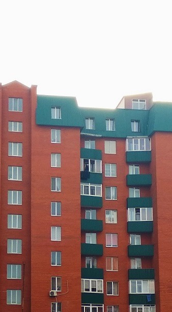 Image of the outside of a tall apartment building.