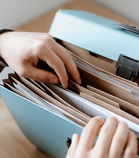 Image of a person looking through a file folder for real estate documents.