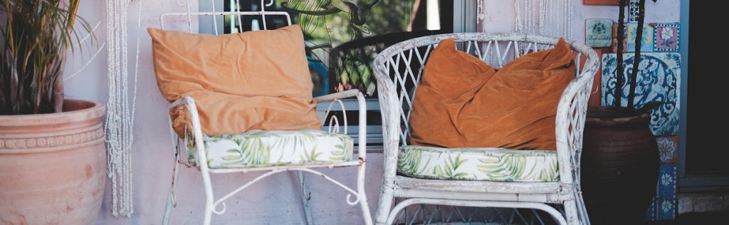 Two chairs sitting on the porch of an off the grid house