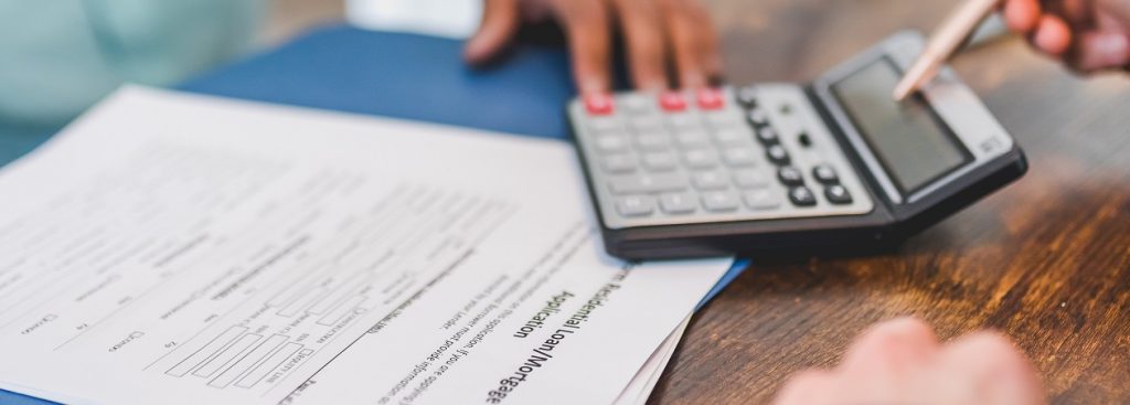 Calculator sitting on top of a mortgage application.