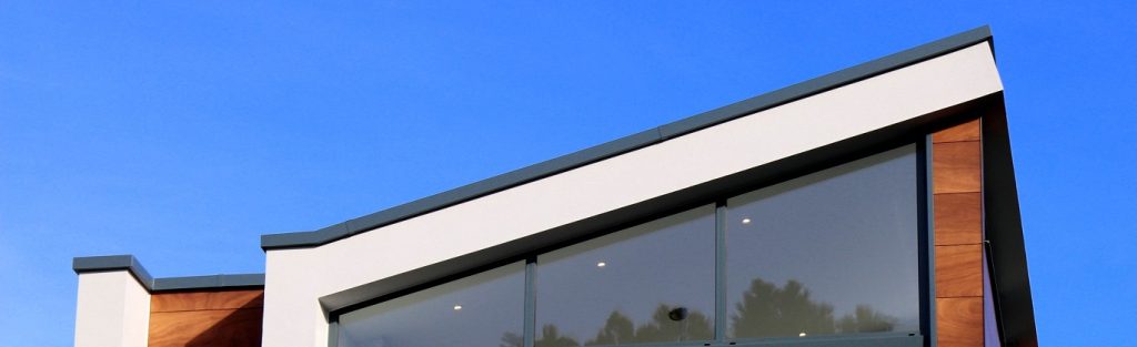 View of the top of a modern house from the outside with a blue sky in the background